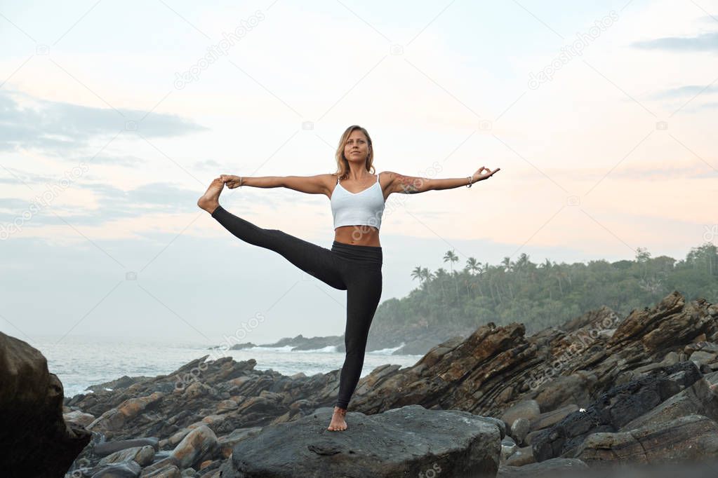 Woman Practicing Yoga in the Nature. Meditating Outdoors. Landscape background