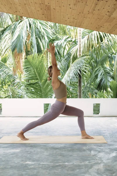 Mulher praticando Yoga avançado no tapete orgânico. Série de Poses de Yoga. Fundo tropical — Fotografia de Stock