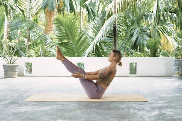 Mulher praticando Yoga avançado no tapete orgânico. Série de Poses de Yoga. Fundo tropical — Fotografia de Stock