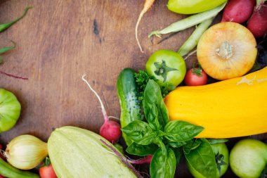 Tahta karatahtanın üstündeki bahçelerden taze hasat. Havuç, domates, biber, salatalık, soğan, kabak, turp, maydanoz..