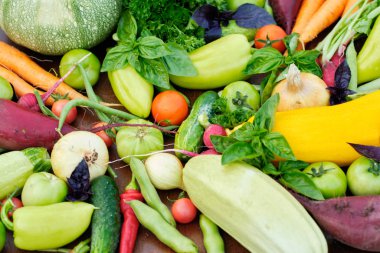 Tahta karatahtanın üstündeki bahçelerden taze hasat. Havuç, domates, biber, salatalık, soğan, kabak, turp, maydanoz..