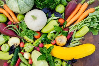 Tahta karatahtanın üstündeki bahçelerden taze hasat. Havuç, domates, biber, salatalık, soğan, kabak, turp, maydanoz..