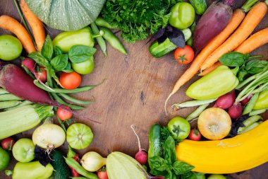 Tahta karatahtanın üstündeki bahçelerden taze hasat. Havuç, domates, biber, salatalık, soğan, kabak, turp, maydanoz..