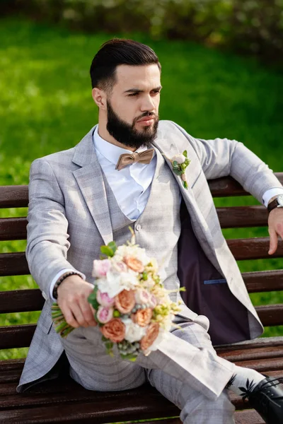 Man klädd Snygg kostym innehav bukett av blomma — Stockfoto