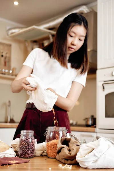 Asian Young Woman Putting Lentils from Fabric Bag