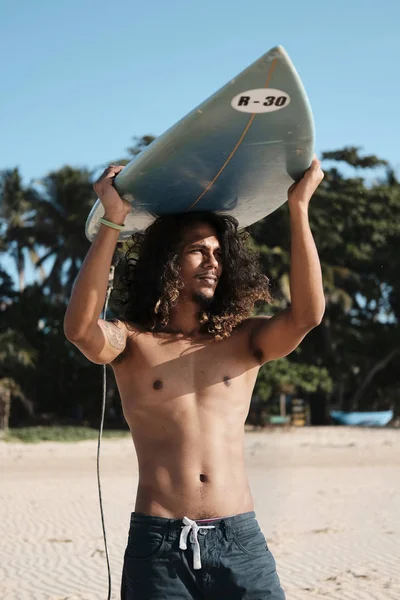 Surfista uomo seduto alla tavola da surf sulla spiaggia di sabbia — Foto Stock