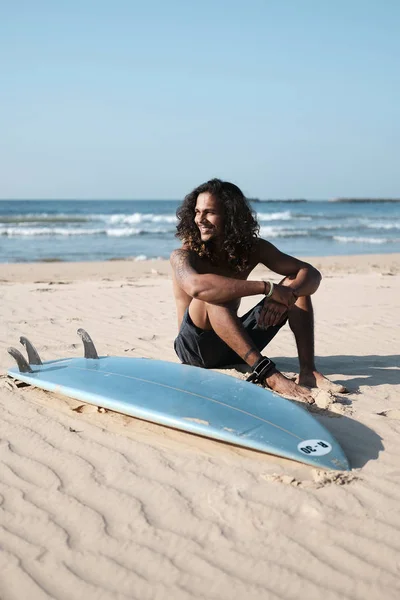 砂浜のサーフボードに座っている男サーファー — ストック写真