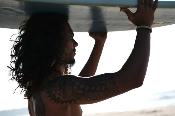 Surfista uomo seduto alla tavola da surf sulla spiaggia di sabbia — Foto Stock