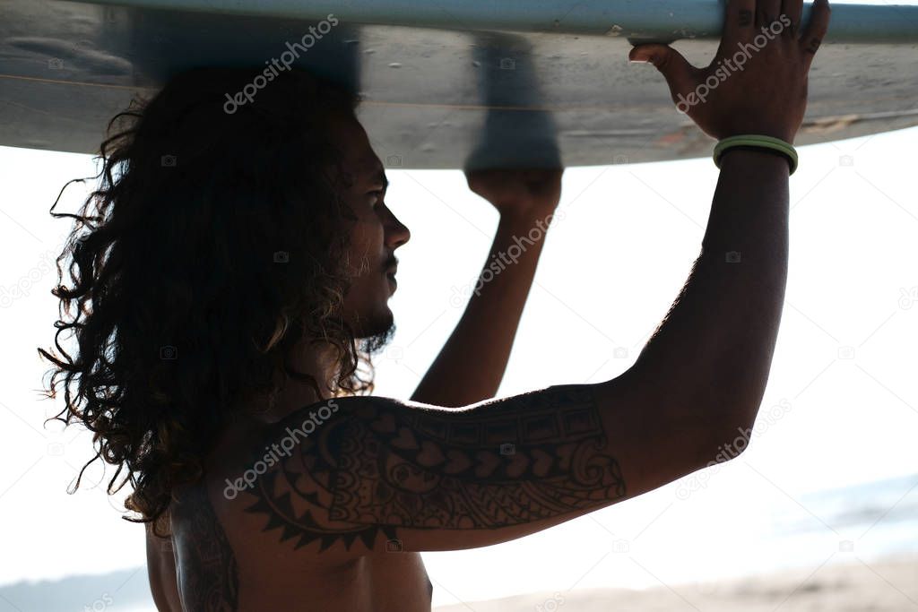 Man Surfer Sitting at Surfboard on Sand Beach