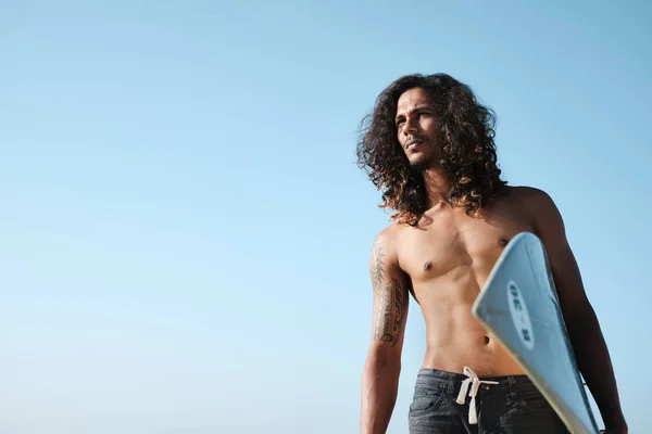 Homem surfista sentado na prancha de surf na praia de areia — Fotografia de Stock