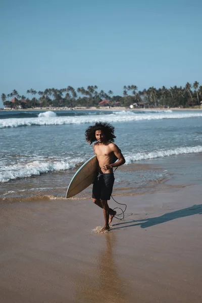 Un surfer stând la Surfboard pe plaja de nisip — Fotografie, imagine de stoc