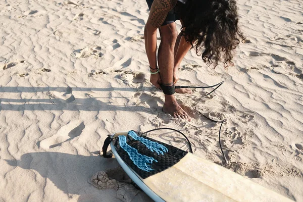 Hombre Surfista sentado en la tabla de surf en la playa de arena —  Fotos de Stock