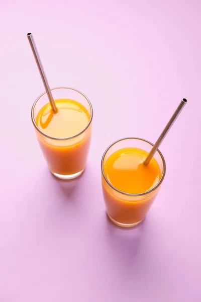 Dois copos de suco de laranja com tubos de aço metálicos — Fotografia de Stock