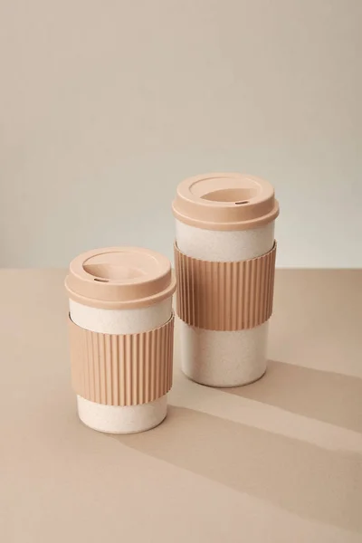 Two Eco Coffee Cup Isolated on Beige Background