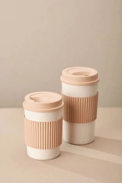 Two Eco Coffee Cup Isolated on Beige Background