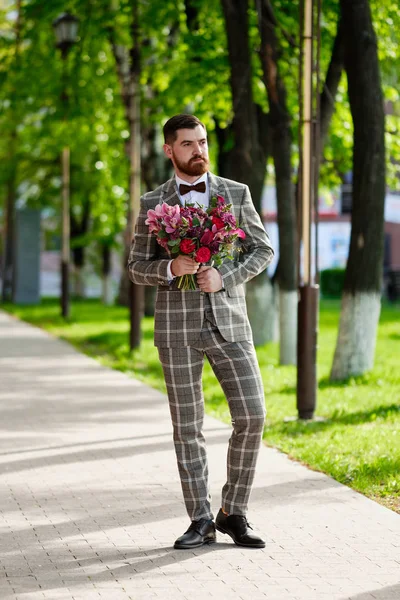 Man klädd Snygg kostym innehav bukett av blomma — Stockfoto