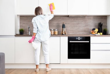 Temizlik Mutfağı 'nı yapan kadın. Sarı bir sünger ve deterjanla mutfağı yıkıyorum. Ev temizliği