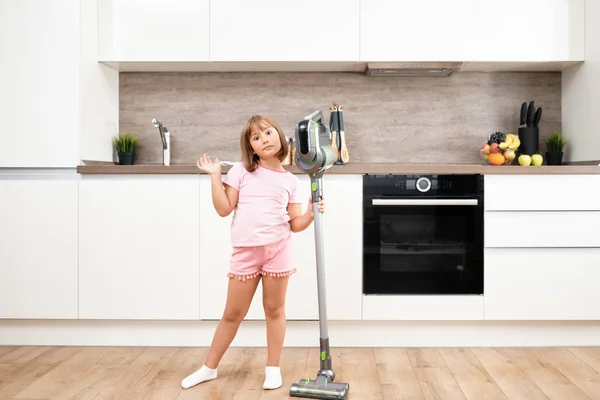 Ragazzina che usa l'aspirapolvere in camera. Aspirazione e pulizia della casa. Lavori domestici — Foto Stock