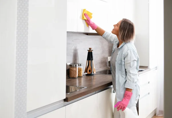 Woman doing Cleaning Kitchen. Washing a kitchen with a yellow Sponge and Detergent. House cleaning — Stock Photo, Image