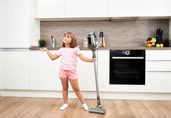 Niña usando aspiradora en la habitación. Aspirando y limpiando la casa. Trabajos domésticos —  Fotos de Stock