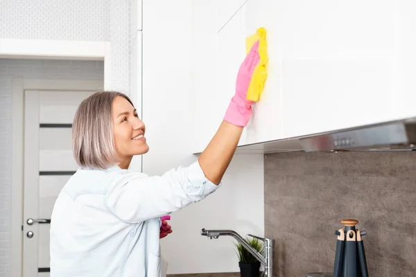 Frau beim Küchenputzen. Eine Küche mit einem gelben Schwamm und Waschmittel waschen. Hausreinigung — Stockfoto