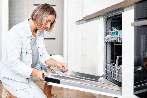 Woman Put Soap Tablet in Dishwasher box. Dishwasher with Dirty Dishes. Washing dishes in the kitchen — Stock Photo, Image