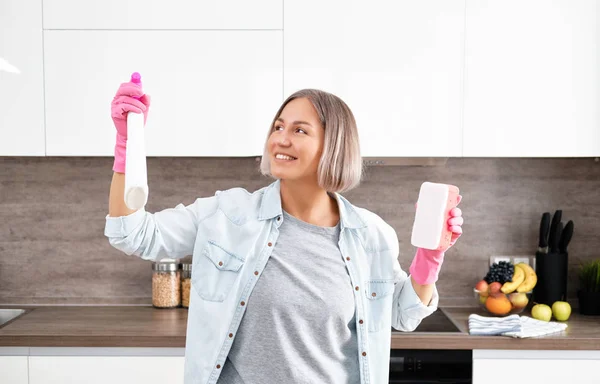 做清洁厨房的女人用黄色的海绵和洗涤剂洗厨房。清扫房屋 — 图库照片