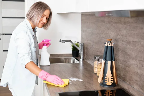 부엌 청소하는 여자. 노란색 스폰지와 디터 건터제로 부엌 세탁하기. 집안 청소 — 스톡 사진