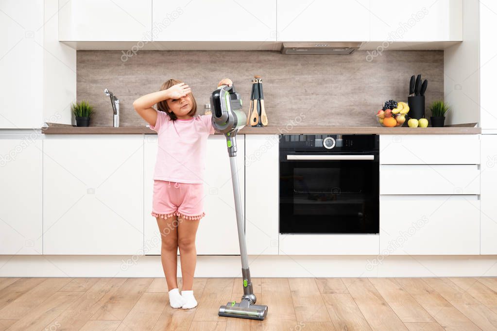 Little girl Using Vacuum Cleaner in Room. Vacuuming and Cleaning the House. Housework