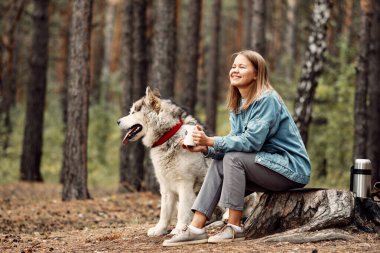 Genç kız ve köpeği Alaska Malamute, Sonbaharda açık havada. Evcil hayvan