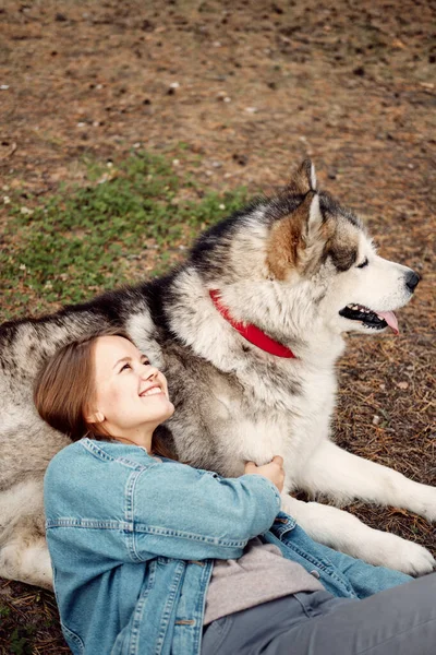 Junges Mädchen mit ihrem Hund, Alaska Malamute, im Herbst im Freien. Haustier — Stockfoto