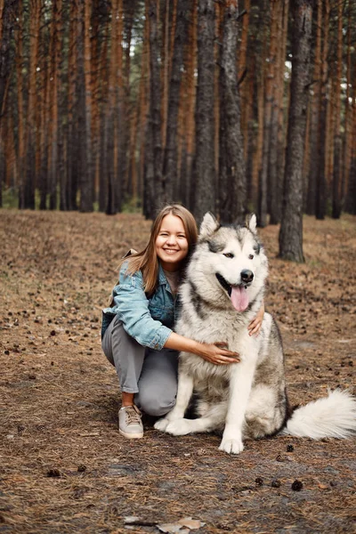 Νεαρή κοπέλα με το σκύλο της, Αλάσκα Μαλαμουτέ, Υπαίθρια το φθινόπωρο. Κατοικίδιο κατοικίδιο — Φωτογραφία Αρχείου