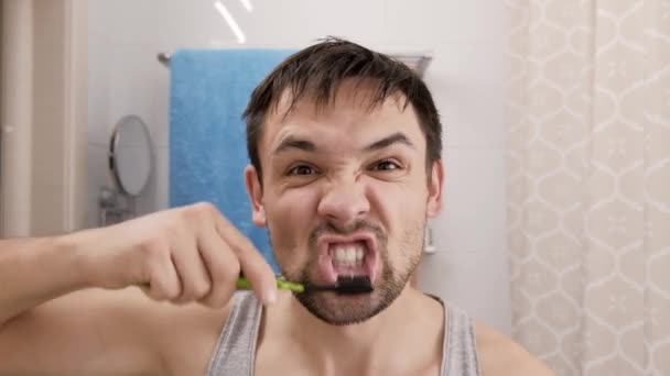 Boldog őrült fiatalember fogat mos bozontos hajjal. A szájhigiénia fogalma — Stock videók