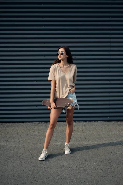 Jonge vrouw met longboard. Meisje skater poseren op longboard bij zonnig weer — Stockfoto