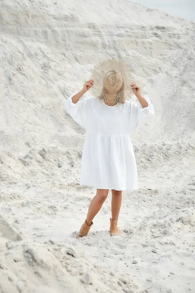 Menina elegante na moda verão vestido de linho chapéu de palha posando na areia. Estilo Boho — Fotografia de Stock