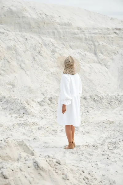 Menina elegante na moda verão vestido de linho chapéu de palha posando na areia. Estilo Boho — Fotografia de Stock