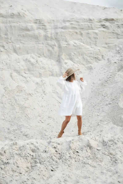 Menina elegante na moda verão vestido de linho chapéu de palha posando na areia. Estilo Boho — Fotografia de Stock