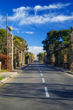 asfalt yol yeşil alan ve bulutların üstünde mavi gökyüzü ile