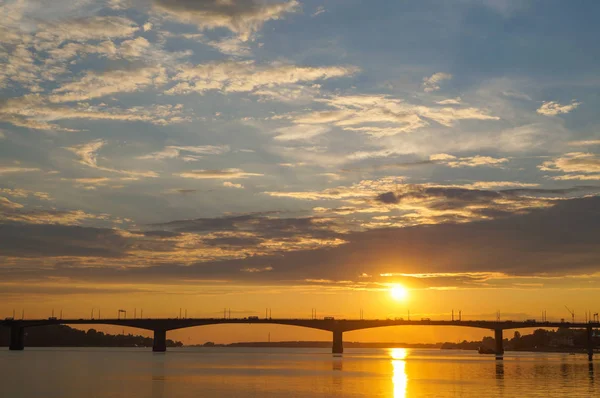 Wunderschöner orangefarbener Sonnenuntergang über der Brücke über der Wolga in Kostroma — Stockfoto
