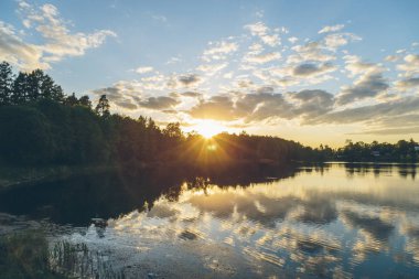 gün batımında gölde yansıyan bulutlar