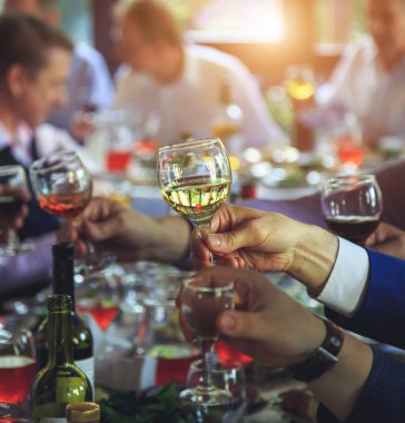 People at the table raise a toast clipart