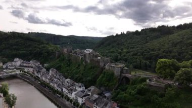 Ardennes 'in yemyeşil yeşillikleriyle çevrili büyüleyici Bouillon Kalesi' nde dolaş. Doğa ve tarihin harmanlandığı canlı yaz atmosferinin tadını çıkarın..