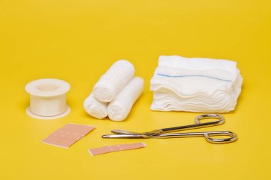 Plasters and bandages with Scissors and syringe on a yellow background clipart