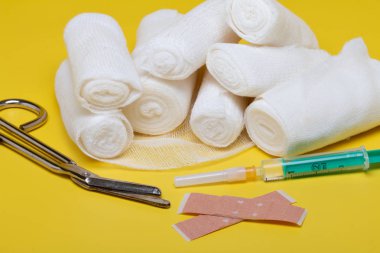 Sıva ve bandaj makas ve sarı bir arka plan üzerinde şırınga ile