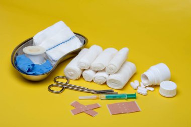 Sıva ve bandaj makas ve sarı bir arka plan üzerinde şırınga ile