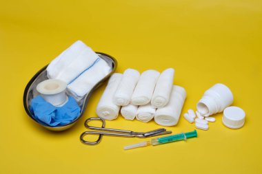 Sıva ve bandaj makas ve sarı bir arka plan üzerinde şırınga ile