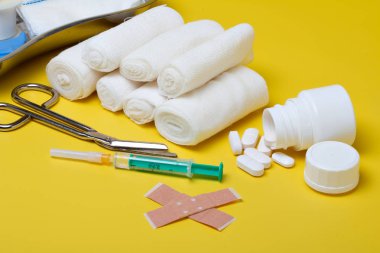 Sıva ve bandaj makas ve sarı bir arka plan üzerinde şırınga ile