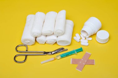 Sıva ve bandaj makas ve sarı bir arka plan üzerinde şırınga ile