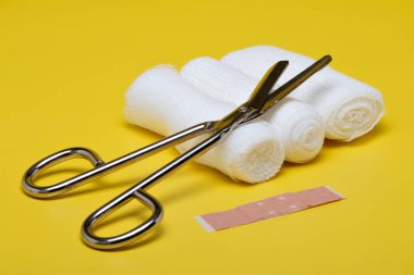 Sıva ve bandaj makas ve sarı bir arka plan üzerinde şırınga ile