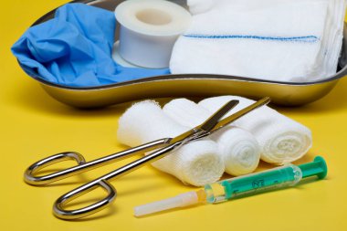 Sıva ve bandaj makas ve sarı bir arka plan üzerinde şırınga ile